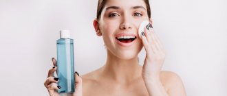 A girl holds a facial tonic in her hands