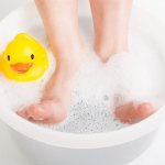 Ножки ребёнка в тёплой ванночке с бикарбонатом натрия